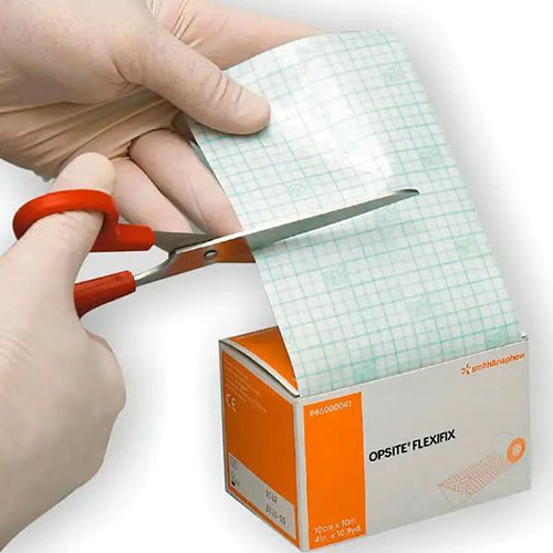 opsite flexifix transparenter Wundverbandin Originalverpackung in orange und weiß inder eine Person mit weißen Handschuhen und roter Schere vom Produkt etwas abschneiden will.jpg